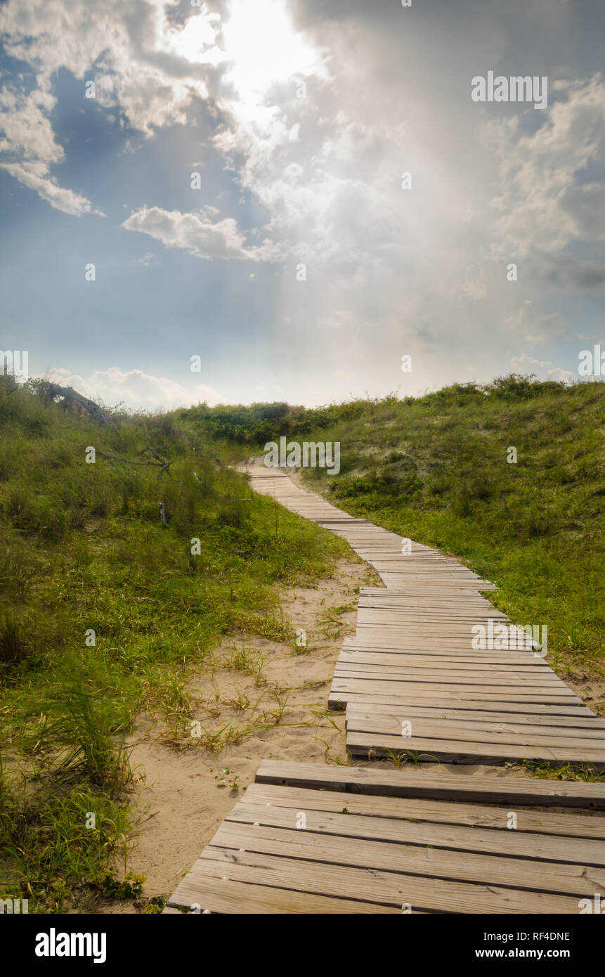 I raggi di cielo su una passerella percorso attraverso le dune in Virginia Beach,Virginia Foto Stock