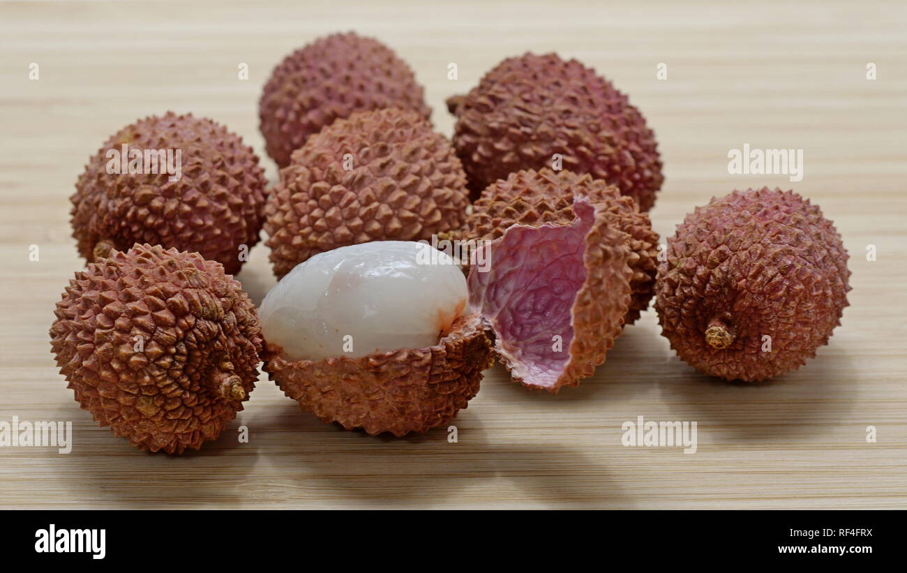 Diversi lychee frutti, uno con buccia aperta Foto Stock