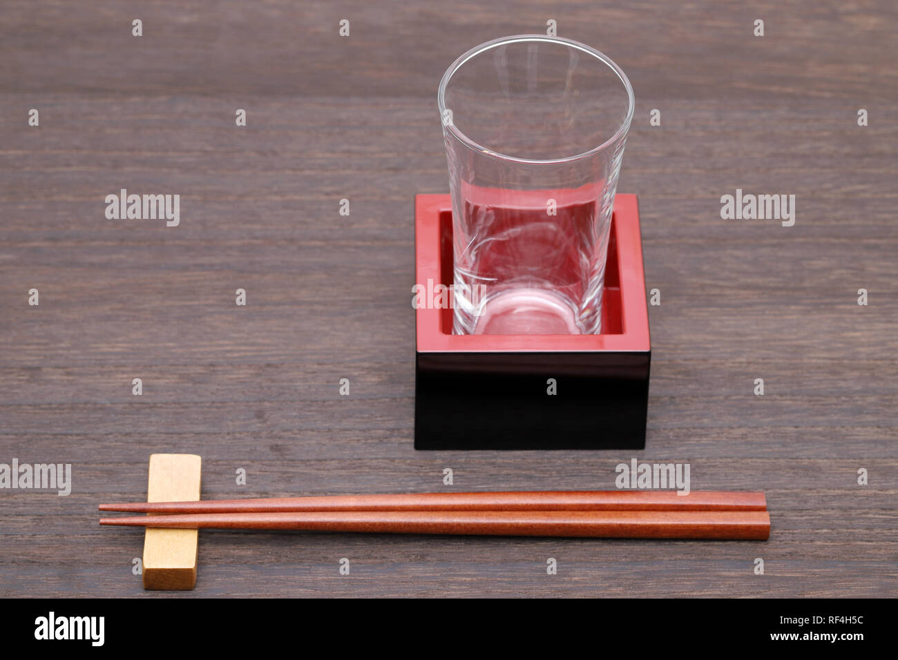 Giapponese scatola in legno masu con calice su un tavolo di legno Foto Stock