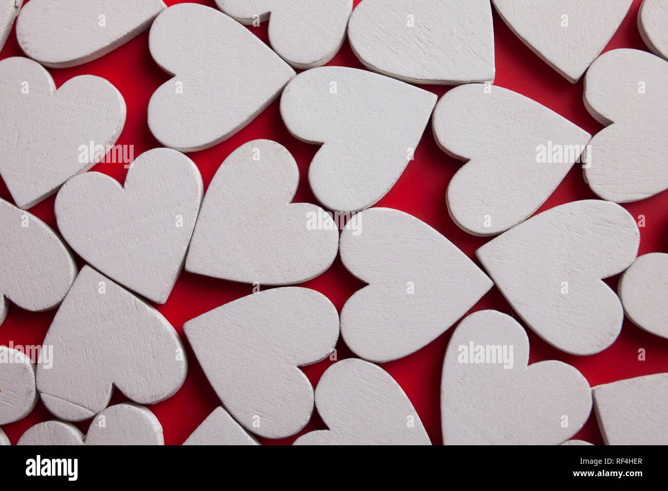 Bianco Cuori di legno su sfondo rosso. Vista dall'alto del modello di San Valentino. Foto Stock