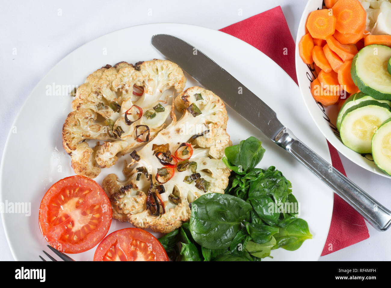 Cavolfiore arrosto di manzo servita con Spinaci appassito e pomodoro grigliate Foto Stock