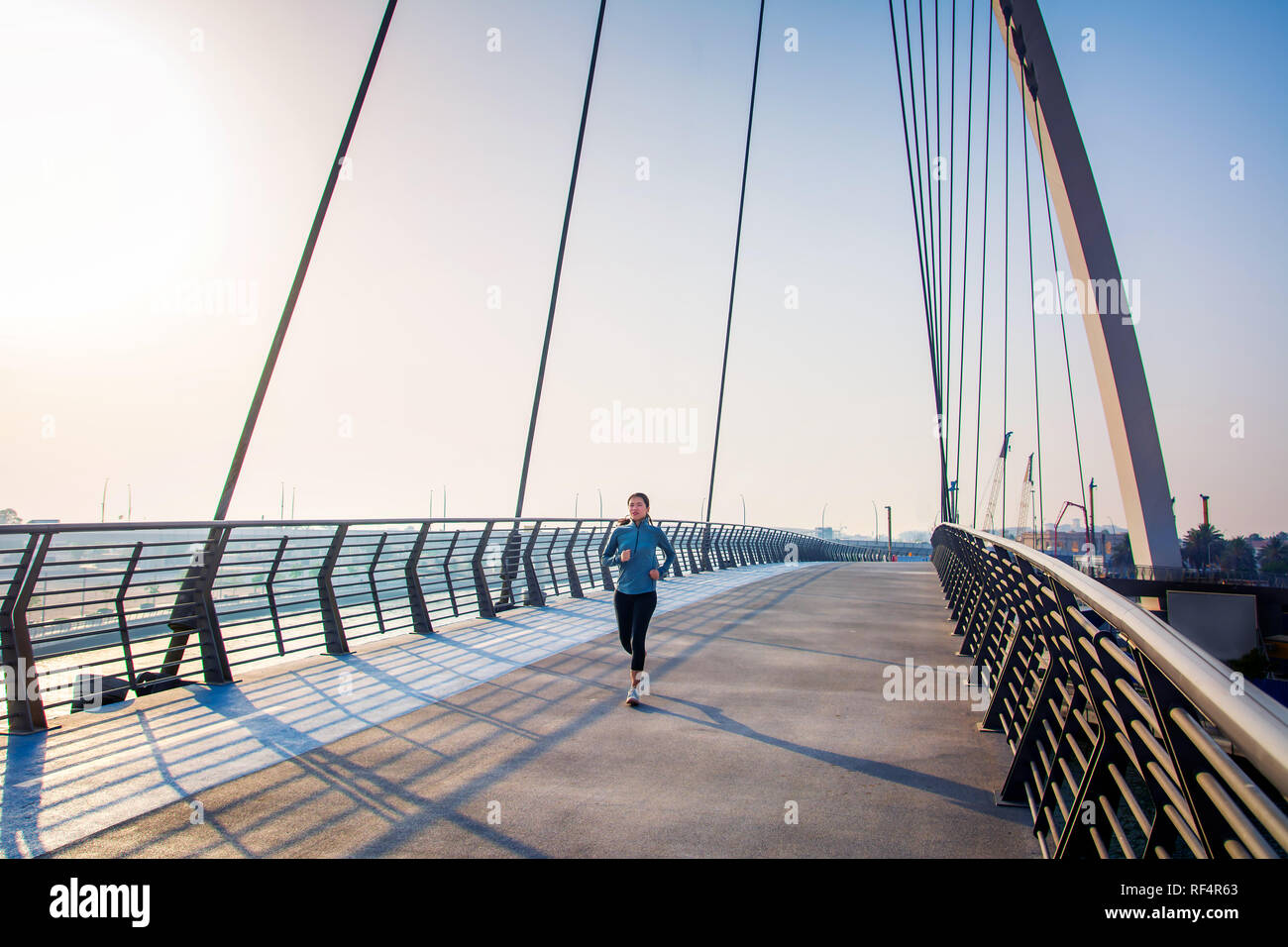 La donna in esecuzione sul ponte in una giornata di sole, attivo su uno stile di vita sano Foto Stock