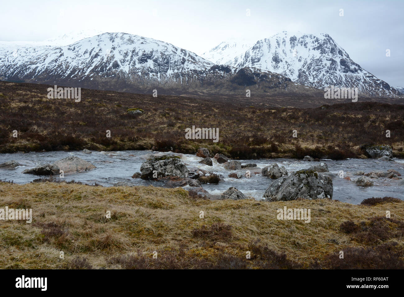 Il fiume Etive con le cime innevate delle Highlands scozzesi in background, Glencoe regione, Scotland, Regno Unito. Foto Stock