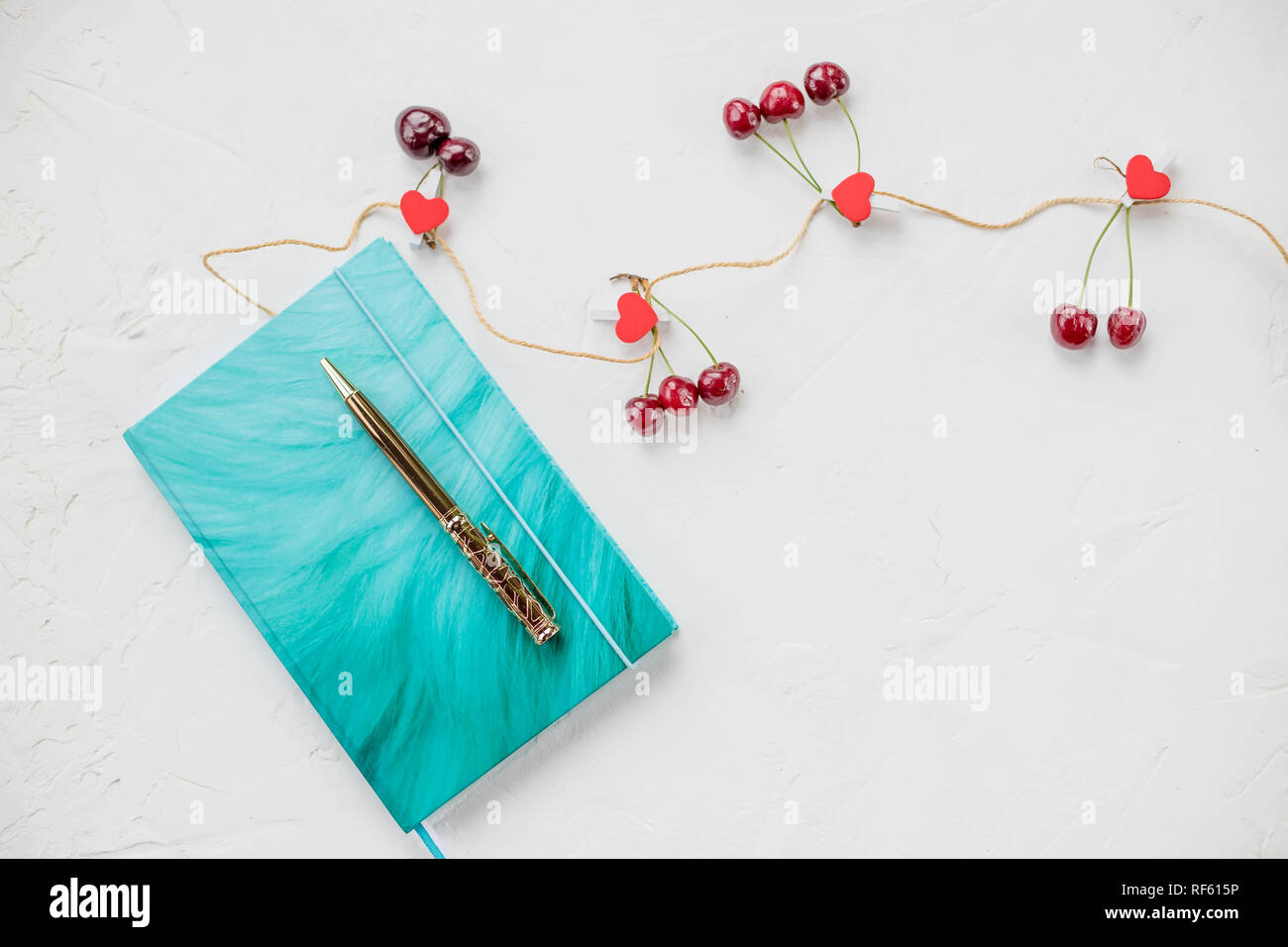 Notebook azure, clip, penna e cuori rossi su sfondo bianco. Lay piatto vista dall'alto luogo per testo .Mock up copia spazio. Obiettivo, media risoluzione, congratulazioni.Il giorno di San Valentino sfondo.madri giorno.La pianificazione e la nozione di sogno Foto Stock