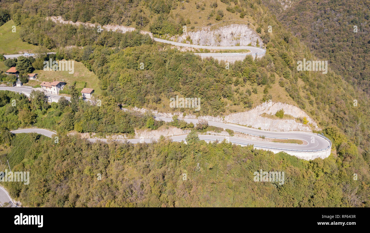 In alto e in basso del drone vista aerea della strada di montagna in Italia dal villaggio di Nembro a Selvino. Incredibile vista aerea della montagna si piega la creazione di Foto Stock