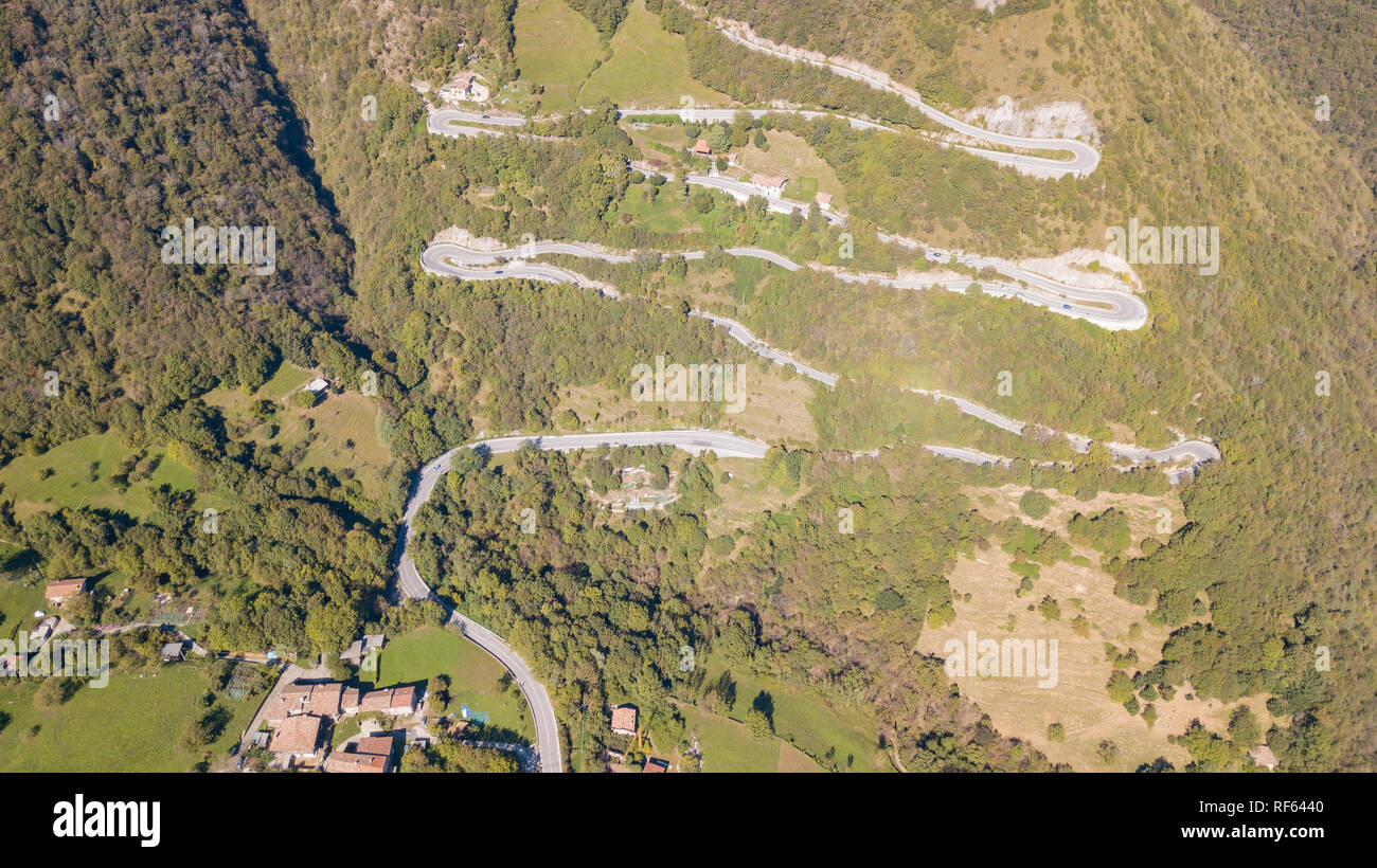 In alto e in basso del drone vista aerea della strada di montagna in Italia dal villaggio di Nembro a Selvino. Incredibile vista aerea della montagna si piega la creazione di Foto Stock