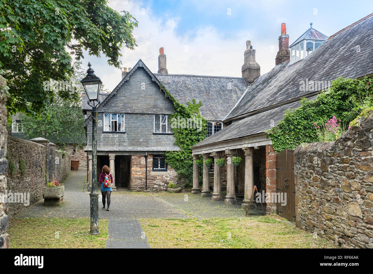 25 Aprile 2018: Totnes, Devon, Regno Unito - la Guildhall, esterno. La donna a piedi attraverso terreni. Foto Stock