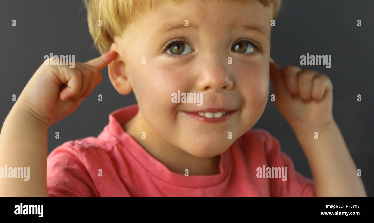 Baby boy toccare il suo orecchio Foto Stock