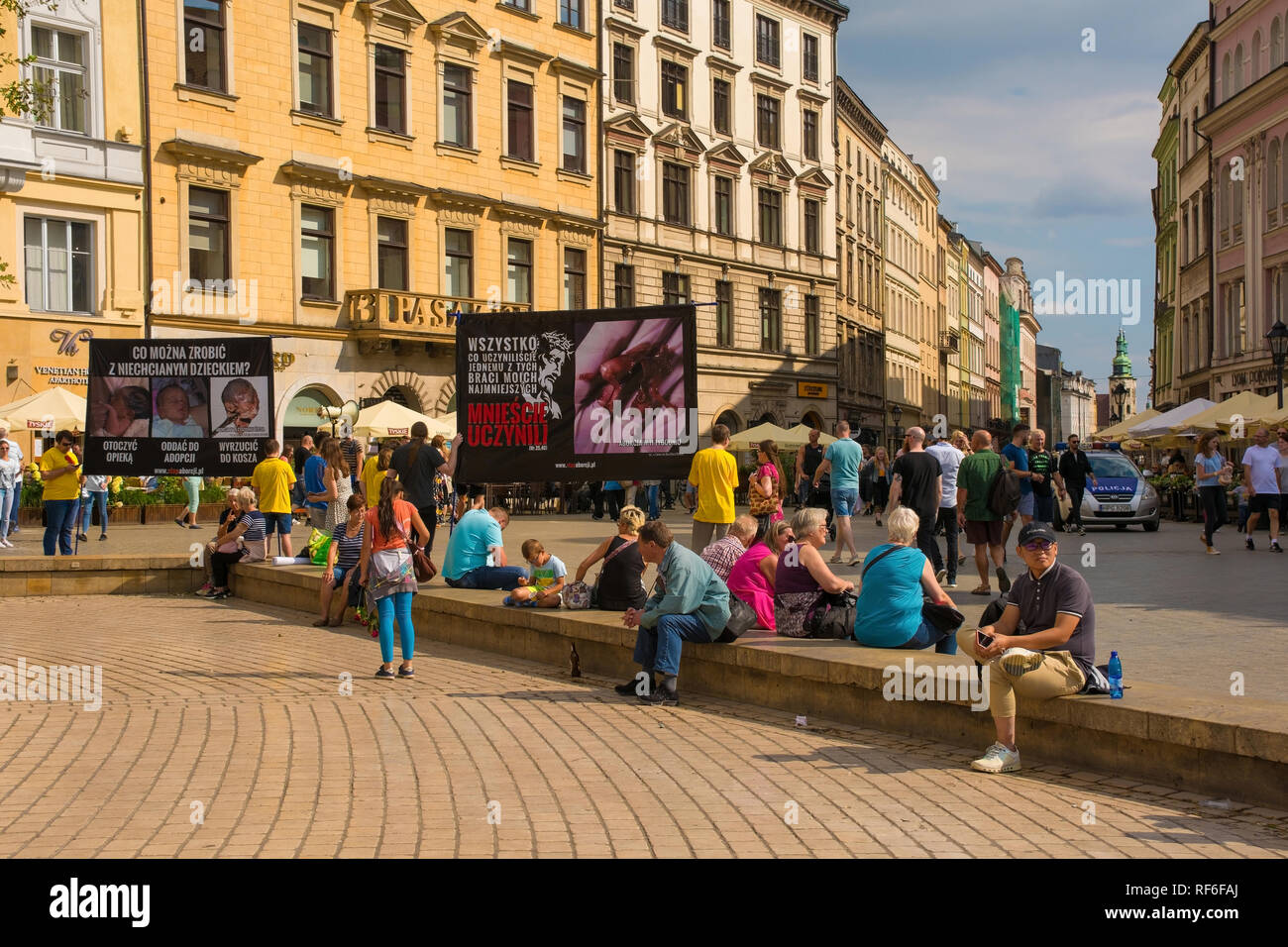 Cracovia in Polonia - 13 luglio 2018. I turisti che ignorano completamente un anti-aborto protesta in Rynek Glowny, la piazza principale nella città vecchia di Cracovia. La polizia m Foto Stock