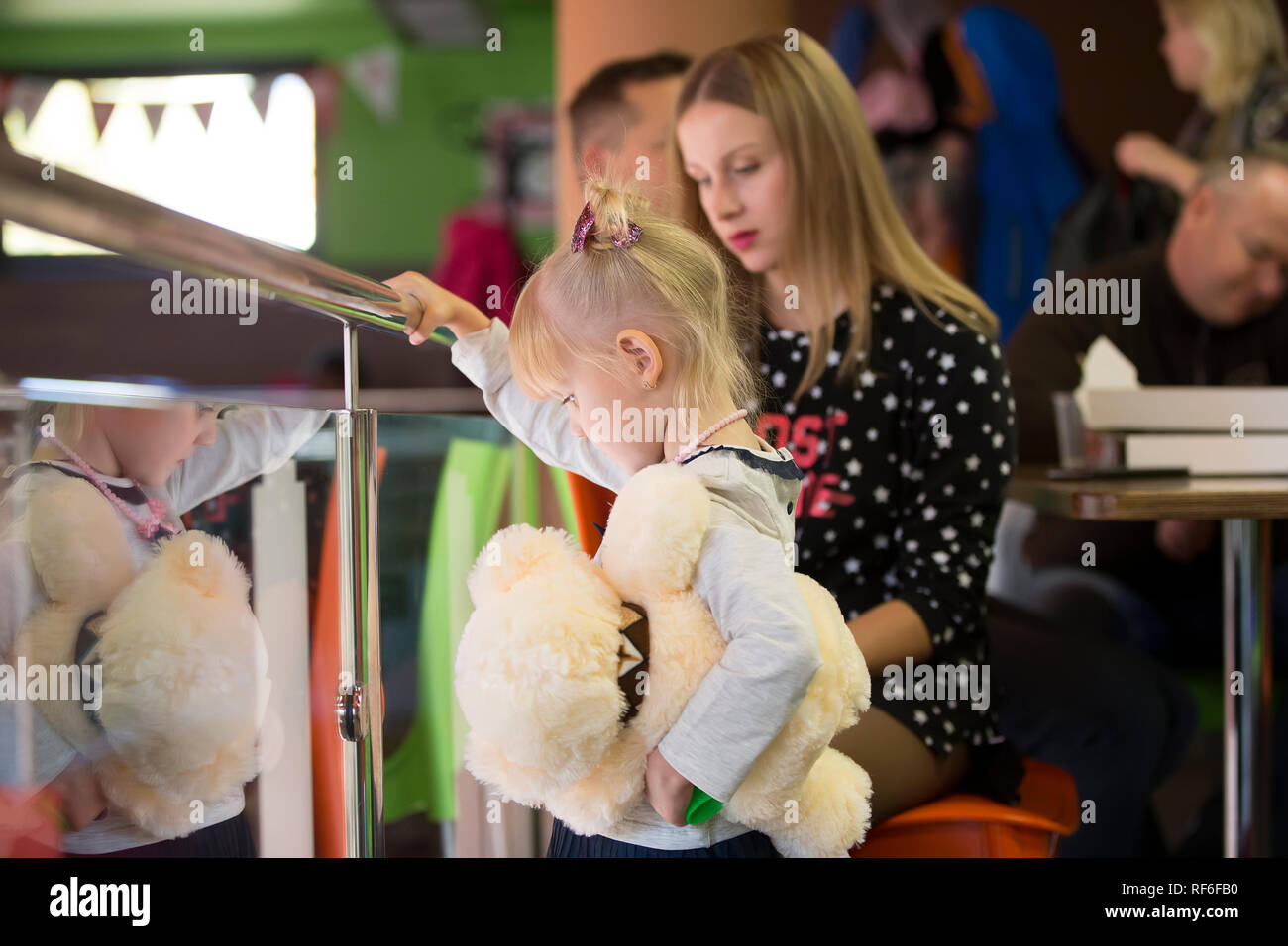 Vacanze in città. I bambini del padiglione.triste bambina con un giocattolo sullo sfondo di MOM Foto Stock