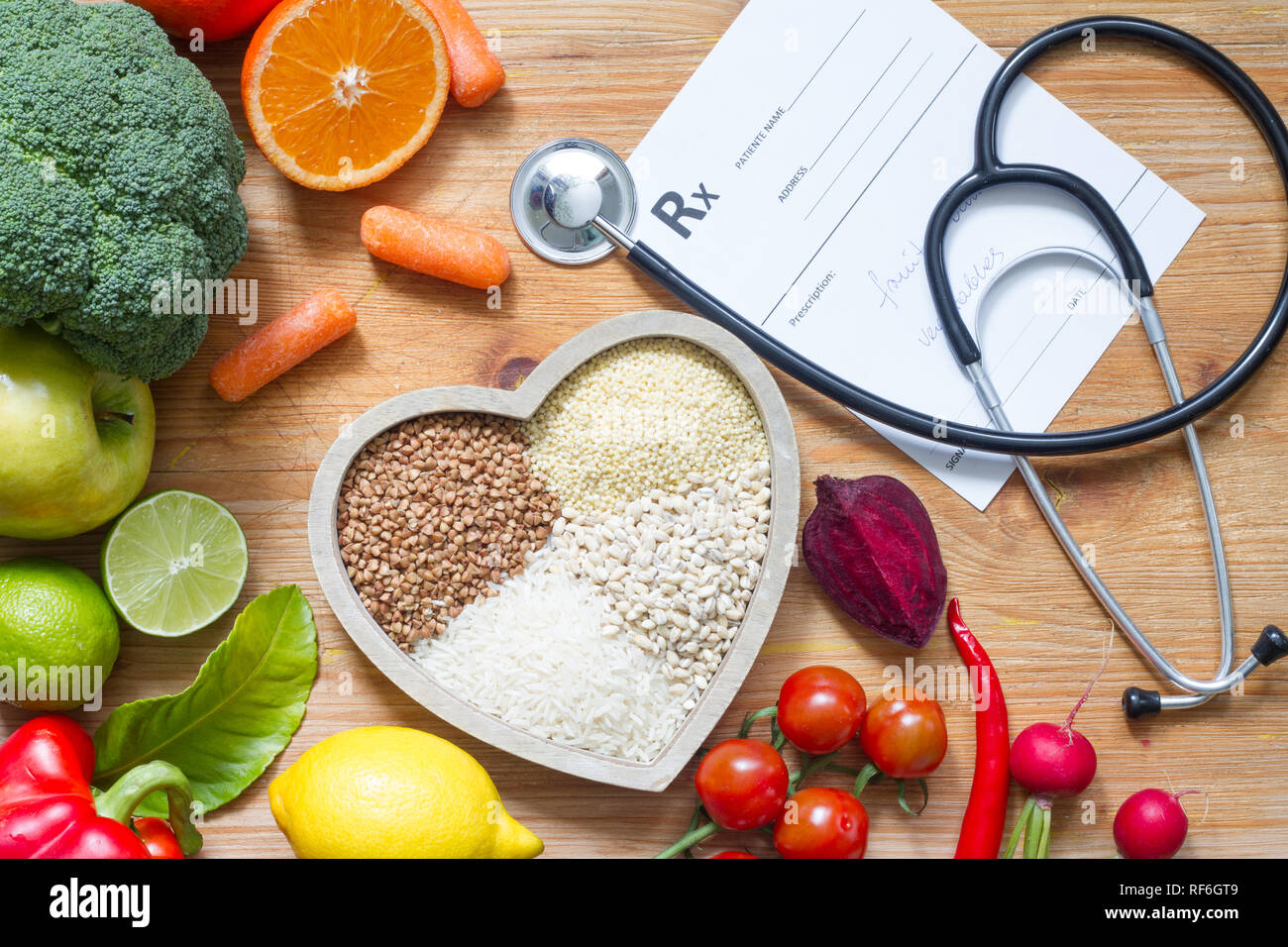 Un sano stile di vita con il cibo vegetariano nel cuore e stetoscopio in medicina alternativa nozione Foto Stock