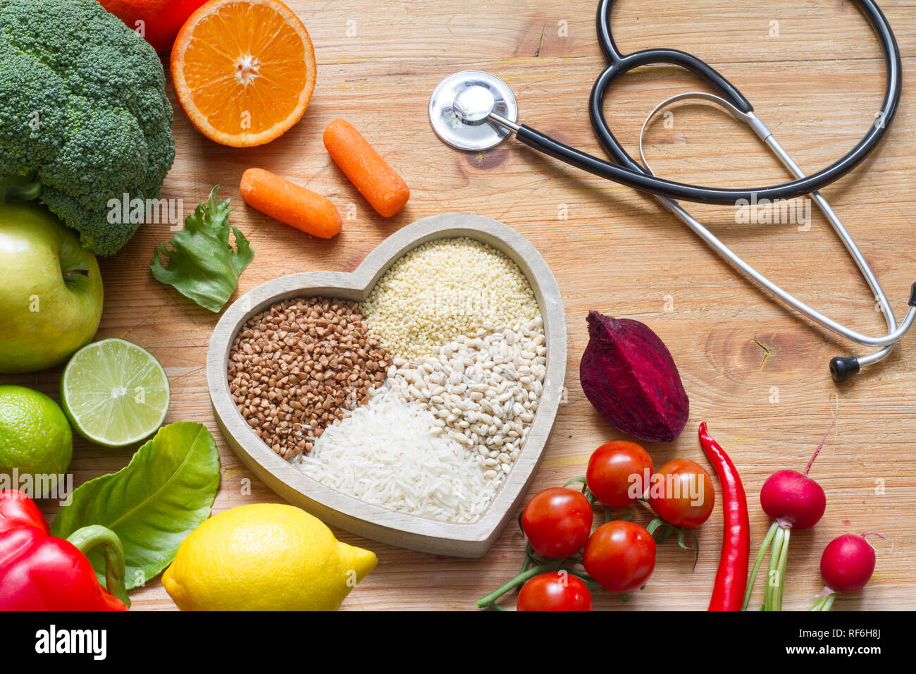 Un sano stile di vita con il cibo vegetariano nel cuore e stetoscopio in medicina alternativa nozione Foto Stock