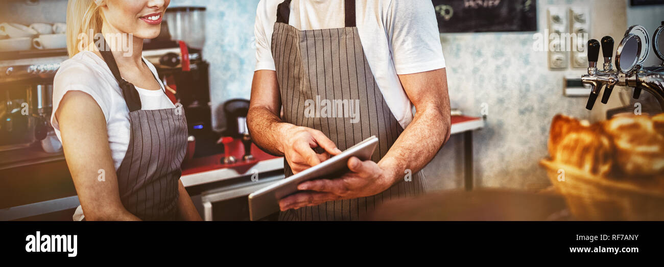 Felice collaboratori utilizzando tavoletta digitale Foto Stock