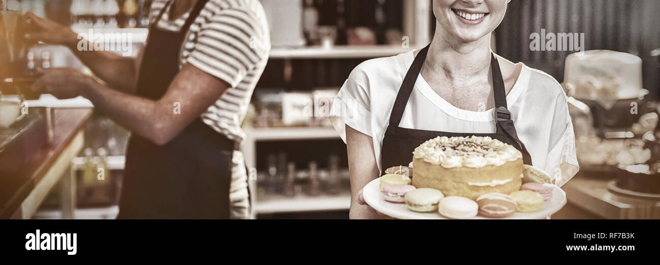 Ritratto di cameriera holding dessert torta sul supporto Foto Stock