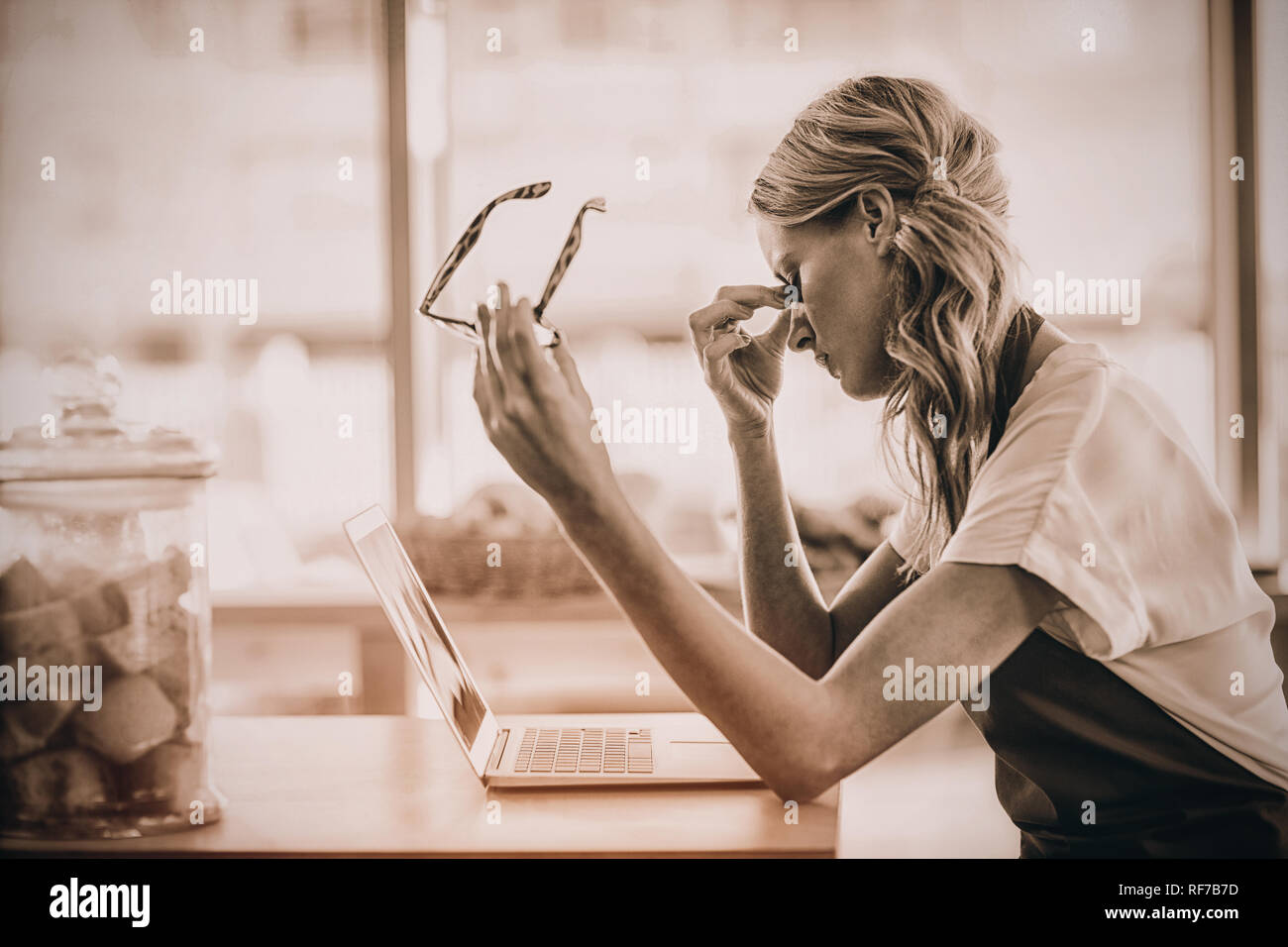 Cameriera seduta a tavola e Utilizzo di computer portatile in café Foto Stock