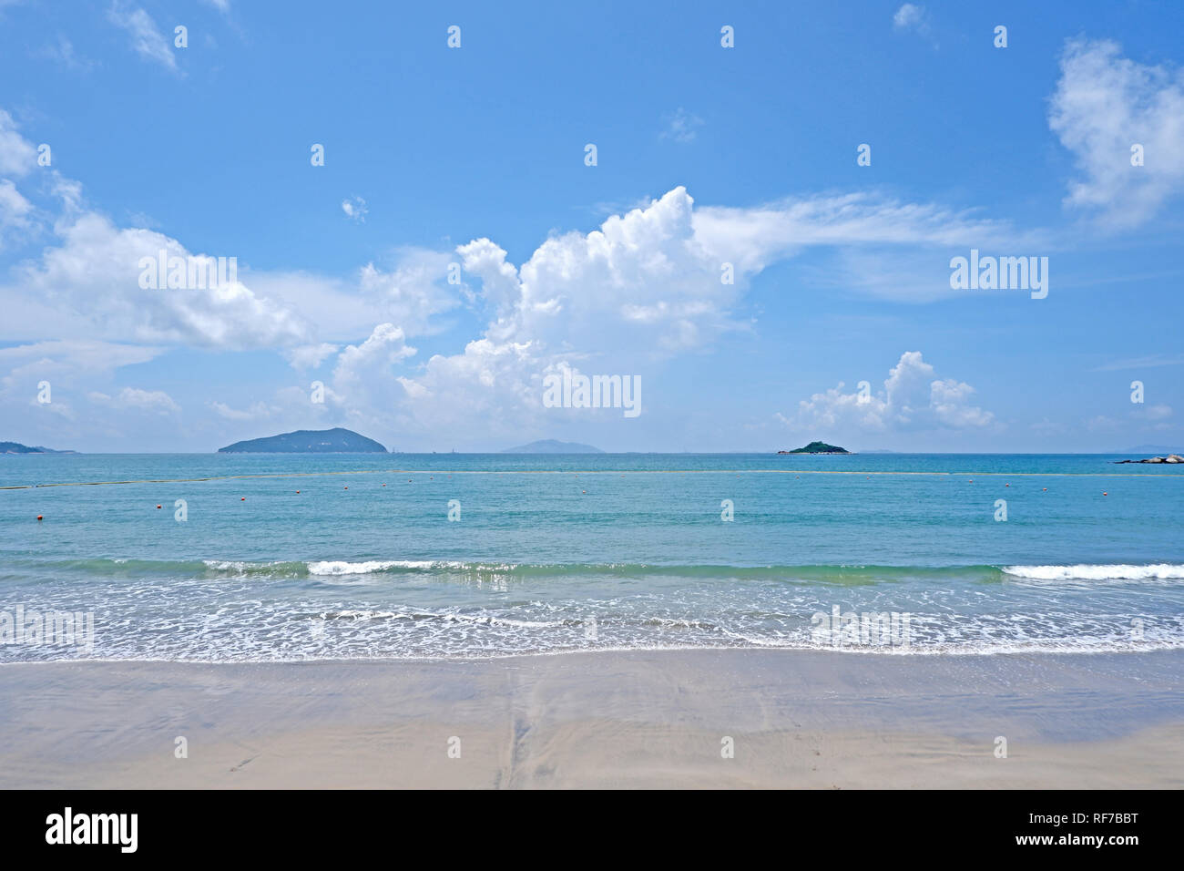 Il cielo blu, nuvola bianca, montagna, beach ocean con wave Foto Stock