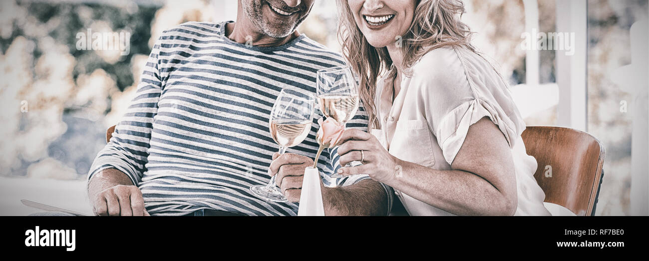 Ritratto di sorridente coppia matura azienda bicchieri di vino Foto Stock
