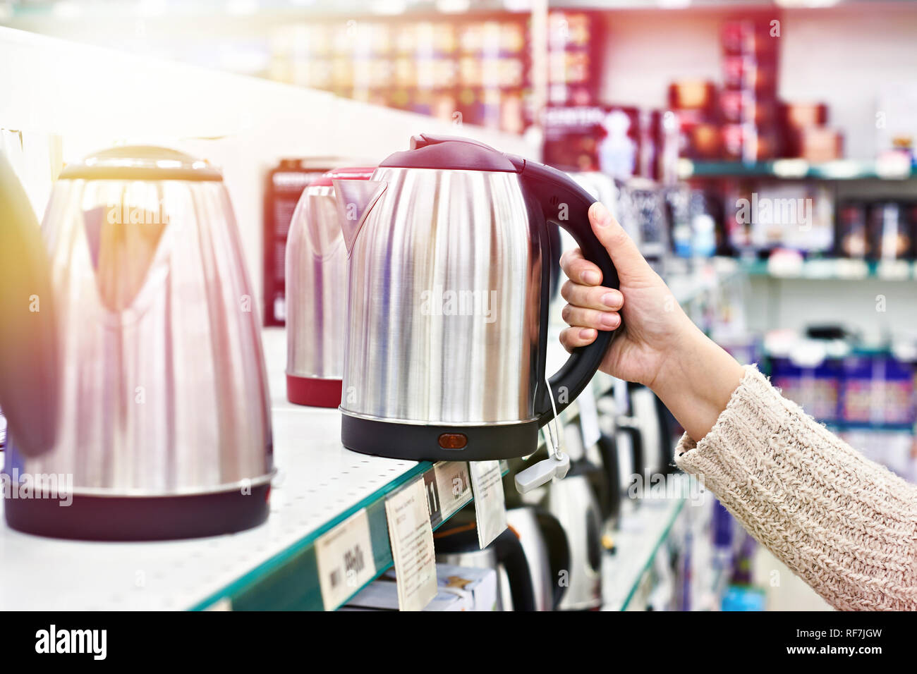 Donna cliente sceglie un bollitore elettrico Foto Stock