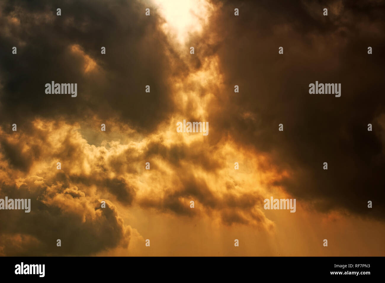 Sole che splende attraverso nuvole scure. Concetto di cielo drammatico e apocalittico. Sfondo di nuvole tuose - concetto di nuvole esplosive. Foto Stock