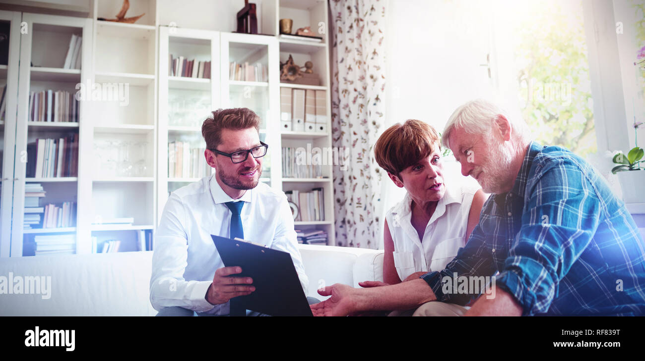 Coppia senior pianificare i loro investimenti con il consulente finanziario Foto Stock