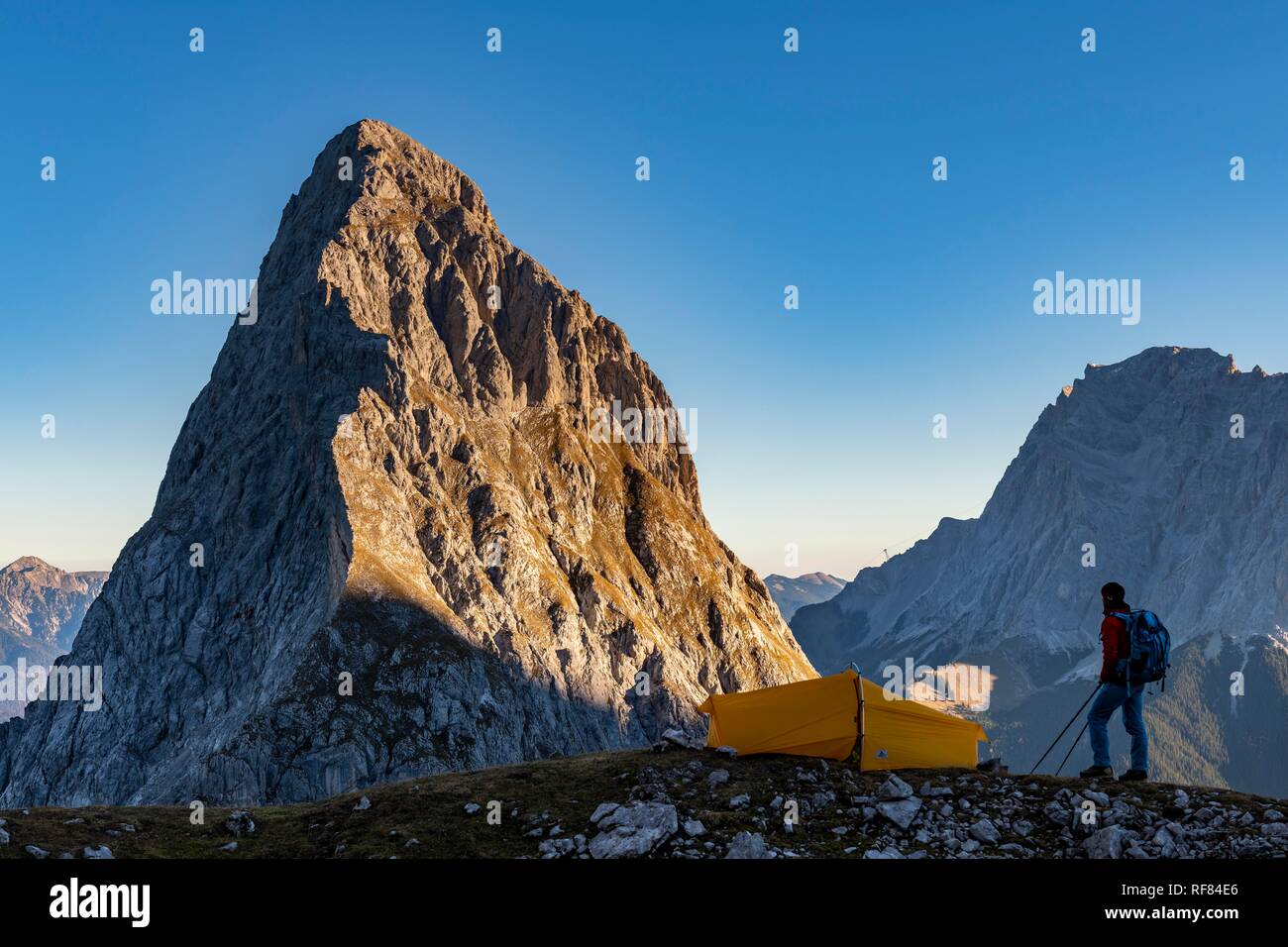 Vertice dell'Sonnenspitze con alpinista e tenda come pure Zugspitze in background, Ehrwald, Außerfern, Tirolo, Austria Foto Stock