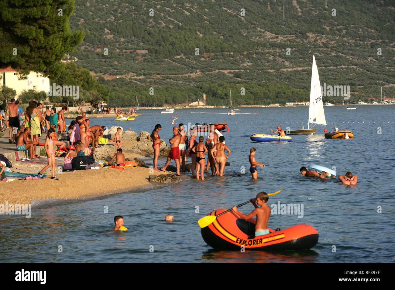 I bagnanti e diportisti al Kovacine campeggio, con la sua spiaggia di cemento, nuoto e imbarcazioni, isola di Cres, Croazia, Europa Foto Stock
