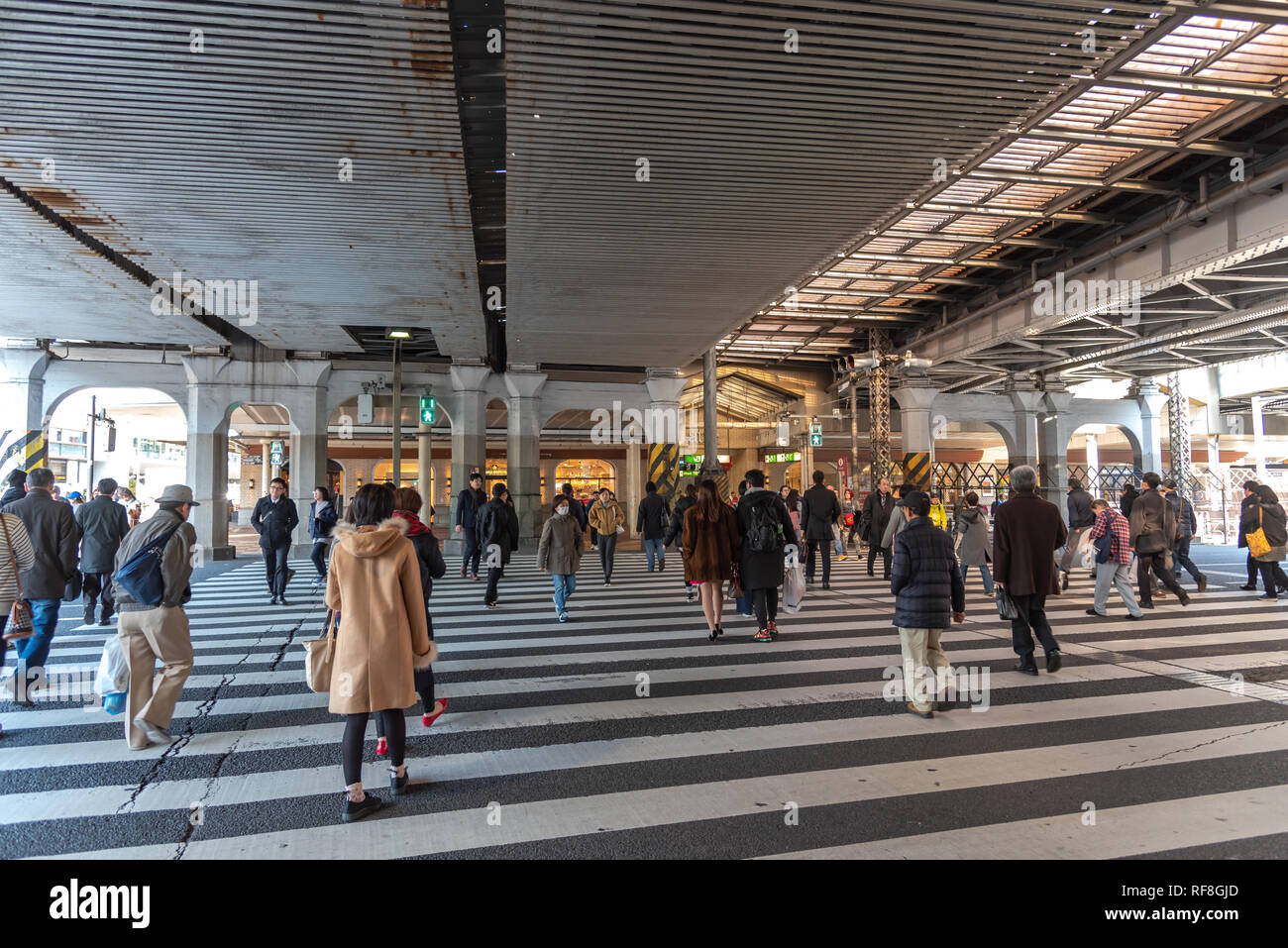 Pedoni affollata che si incrociano in corrispondenza al di fuori della stazione di Ueno a Tokyo in Giappone. I pedoni a passeggiare e a fare shopping presso il quartiere di Ueno in vacanza. Foto Stock