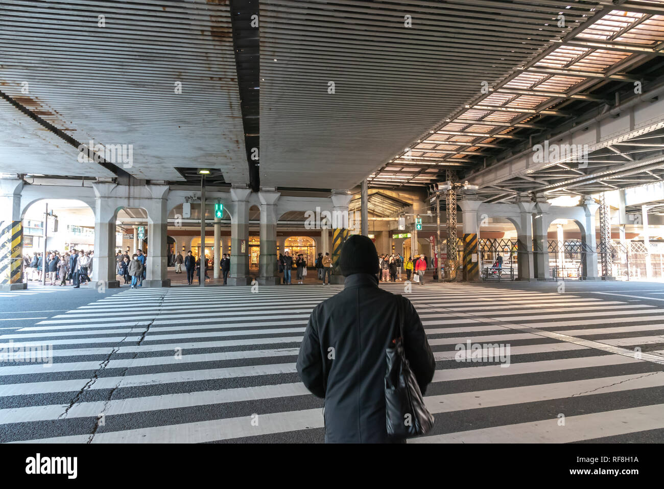 Pedoni affollata che si incrociano in corrispondenza al di fuori della stazione di Ueno a Tokyo in Giappone. I pedoni a passeggiare e a fare shopping presso il quartiere di Ueno in vacanza. Foto Stock