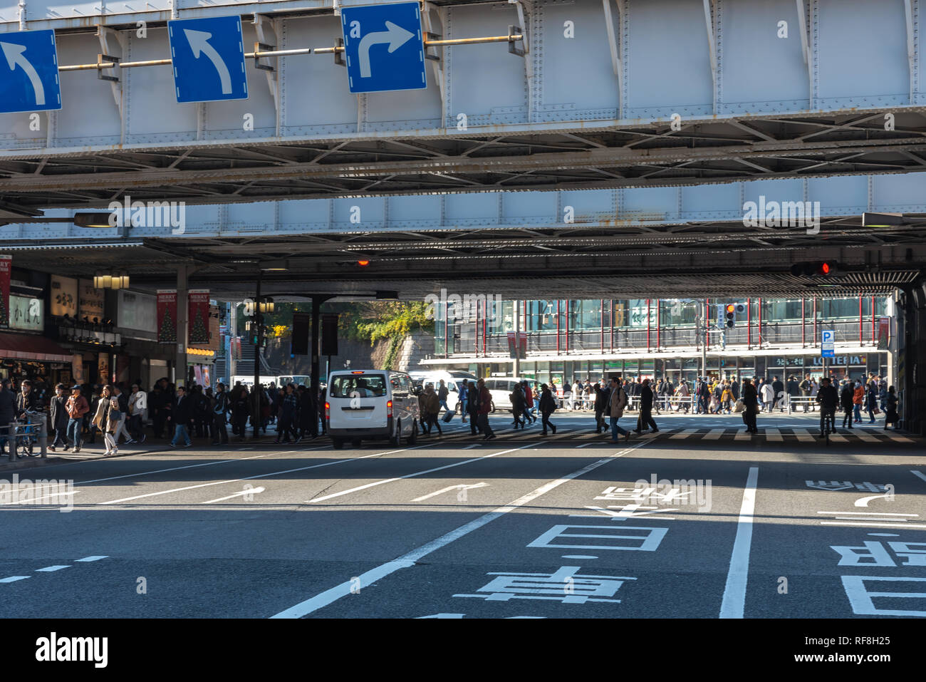 Pedoni affollata che si incrociano in corrispondenza al di fuori della stazione di Ueno a Tokyo in Giappone. I pedoni a passeggiare e a fare shopping presso il quartiere di Ueno in vacanza. Foto Stock