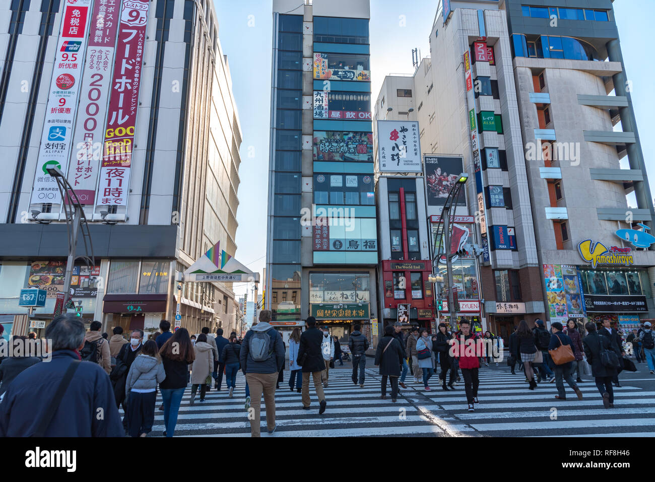 Pedoni affollata che si incrociano in corrispondenza al di fuori della stazione di Ueno a Tokyo in Giappone. I pedoni a passeggiare e a fare shopping presso il quartiere di Ueno in vacanza. Foto Stock