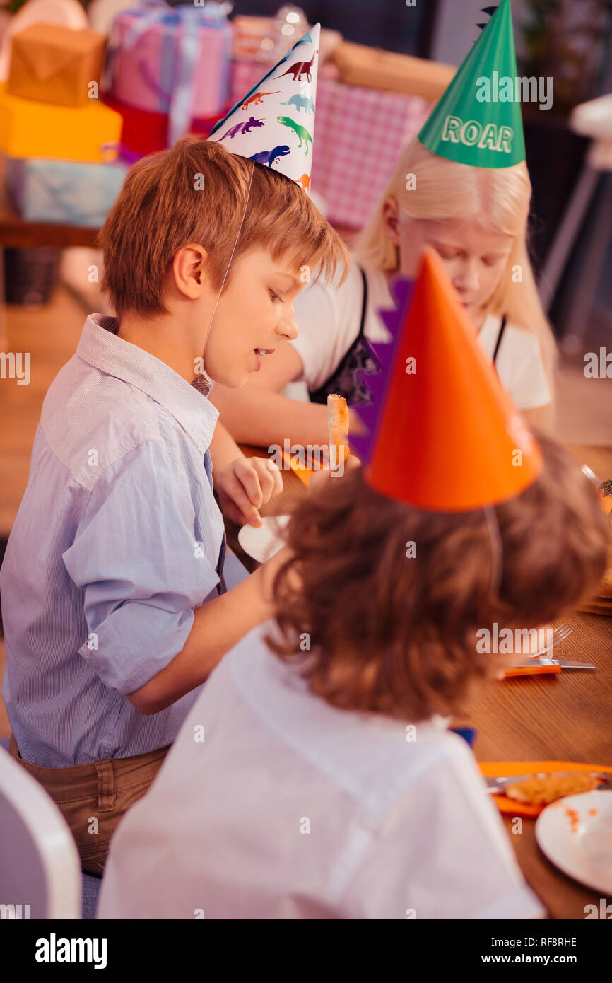 Attento ragazzo biondo guardando il suo piatto Foto Stock