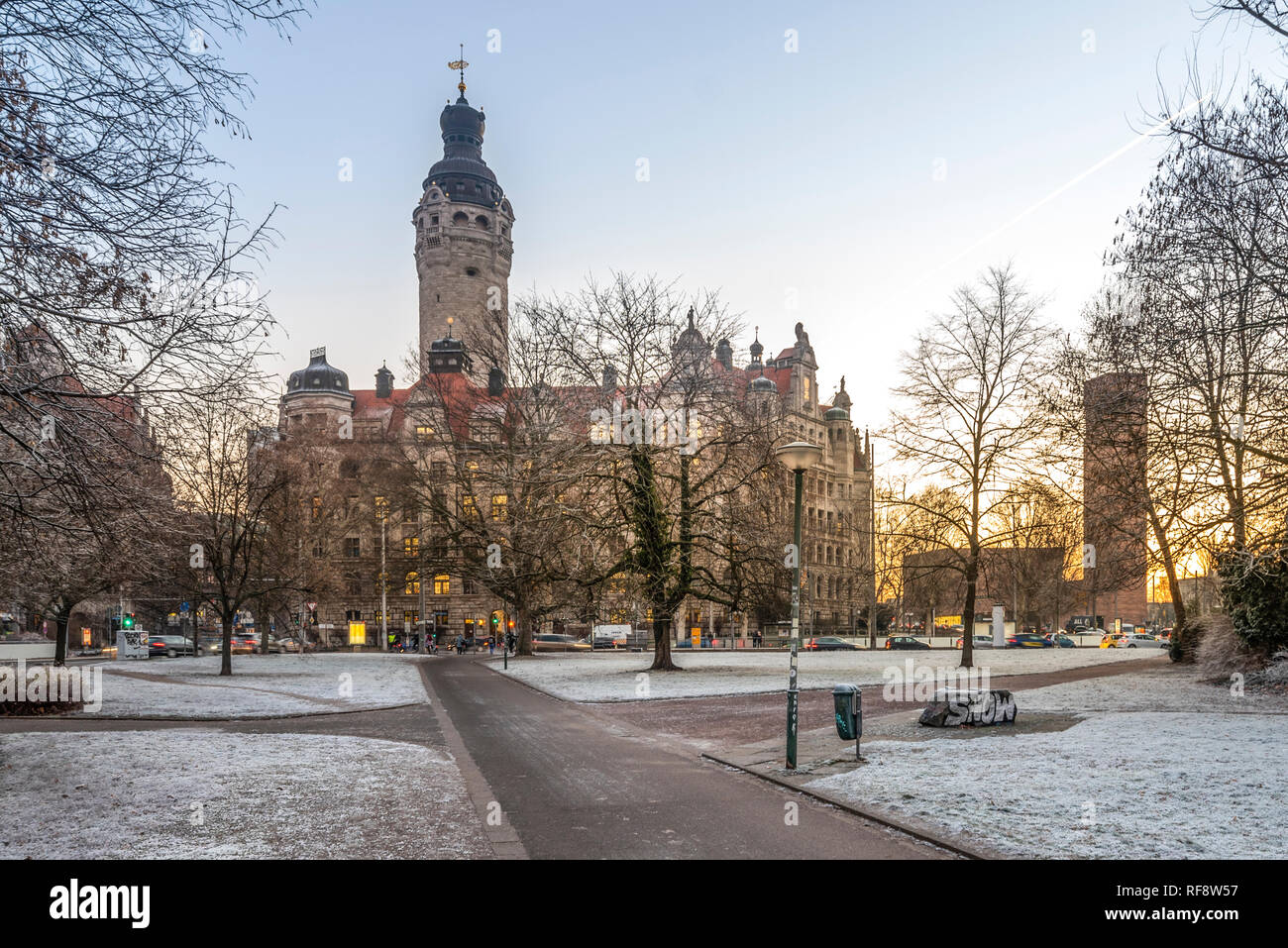 Leipzig im Frost, Neues Rathaus im Licht der aufgehenden Sonne und mit vereisten Bäumen Foto Stock