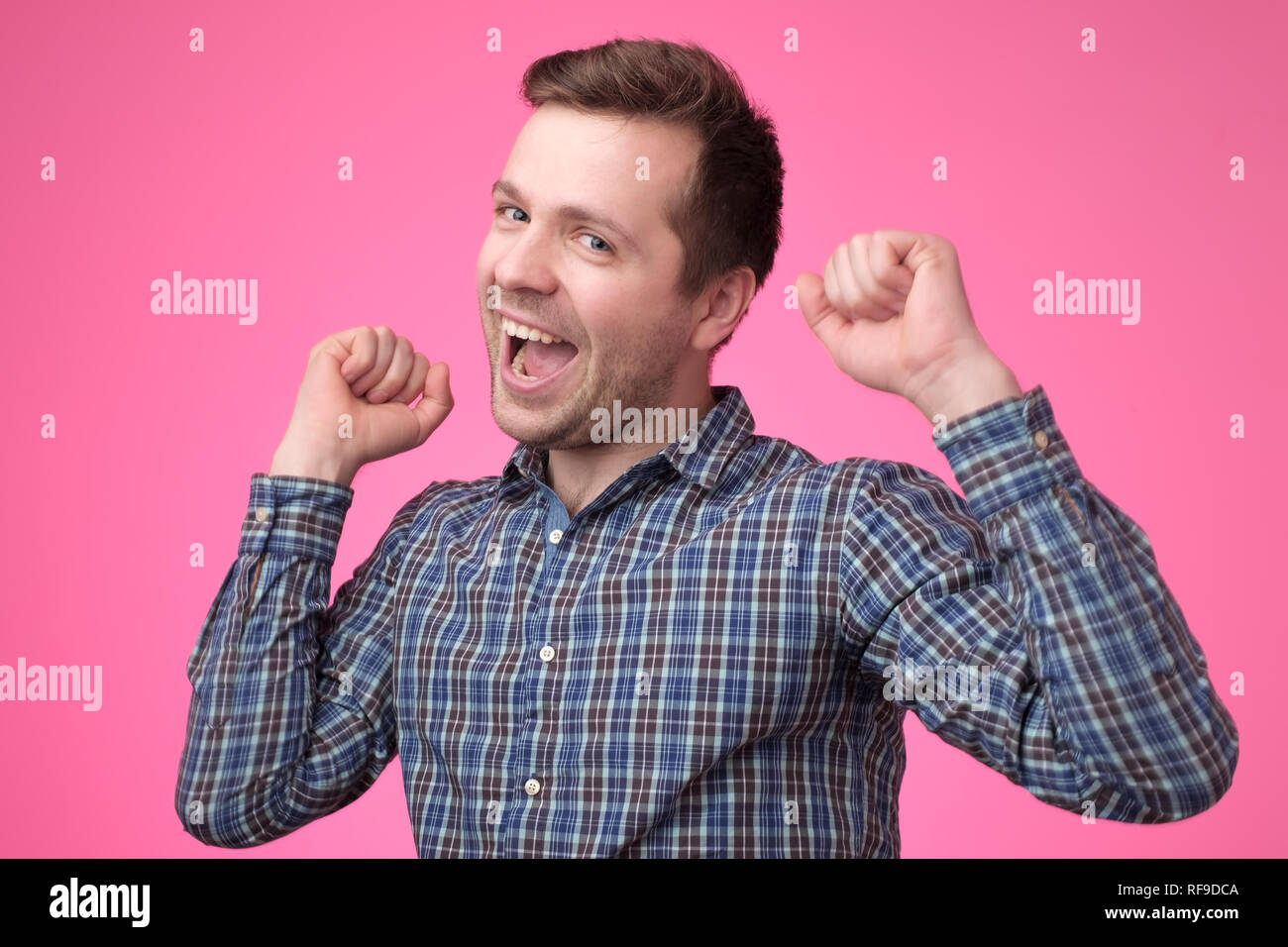 Felice giovane uomo europeo gesticolando e sorridente Foto Stock