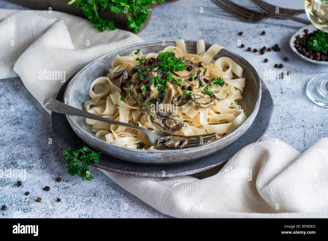 Tagliatelle di pasta e funghi in salsa cremosa con il brandy e il pepe in grani Foto Stock