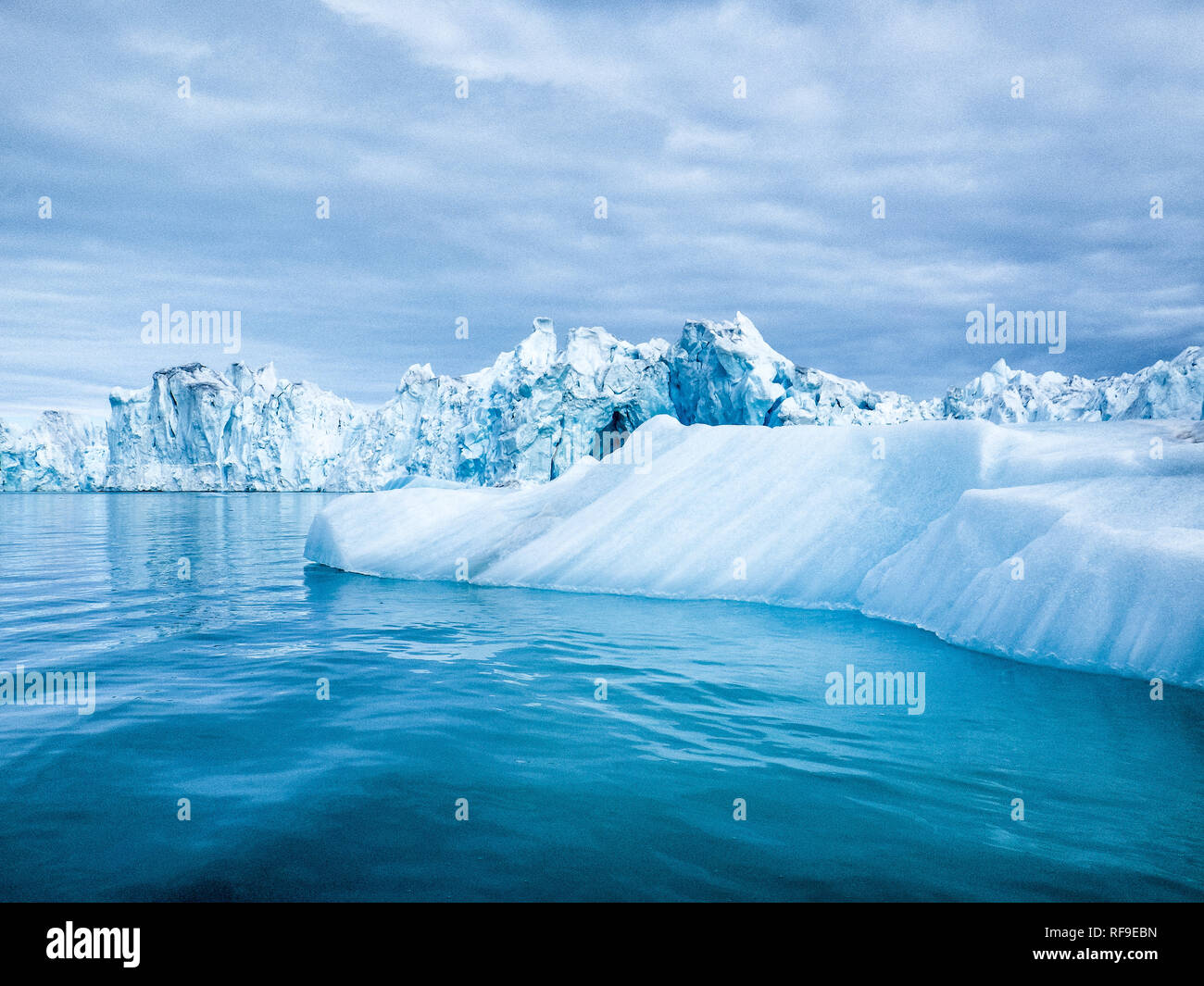 LONGYEARBYEN, Svalbard — gli iceberg e i ghiacciai nei pressi di Longyearbyen, nell'arcipelago artico di Svalbard. Queste splendide strutture ghiacciate non solo incarnano la bellezza aspra della natura selvaggia artica, ma fungono anche da indicatori cruciali del cambiamento climatico, dei loro cambiamenti e fusioni rivelando informazioni chiave sulle tendenze del riscaldamento globale. Foto Stock