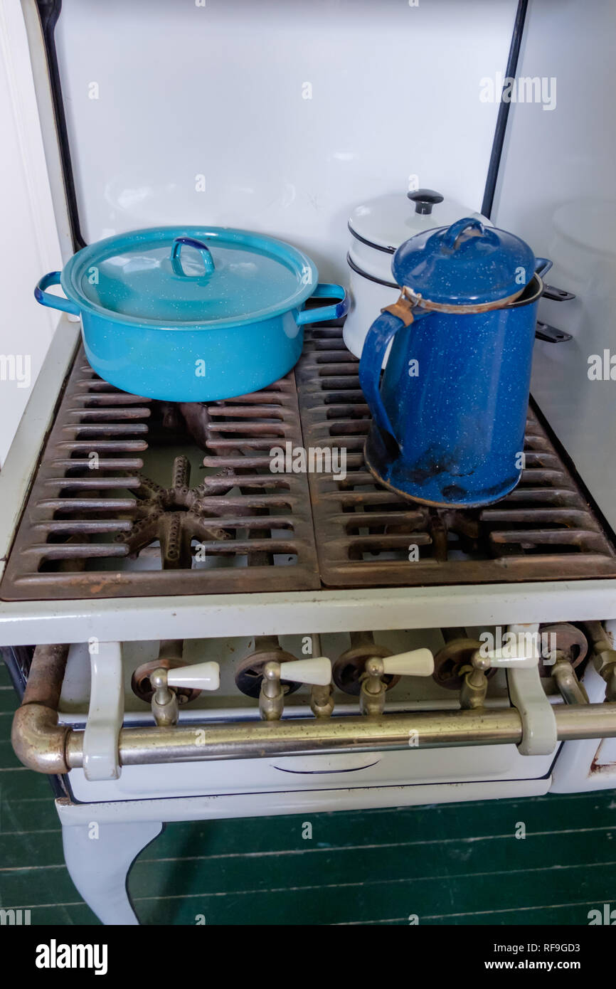 Ghirlanda di antiquariato fornello a gas a 4 fuochi con due blu e uno smalto bianco vintage pentole. Foto Stock