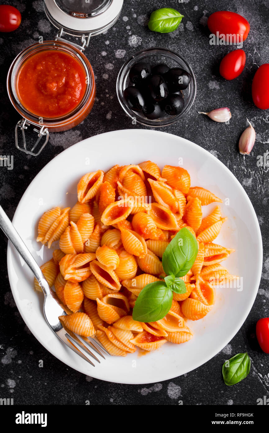 Shell italiana la pasta con la salsa di pomodoro e olive e basilico, cibo classico Foto Stock