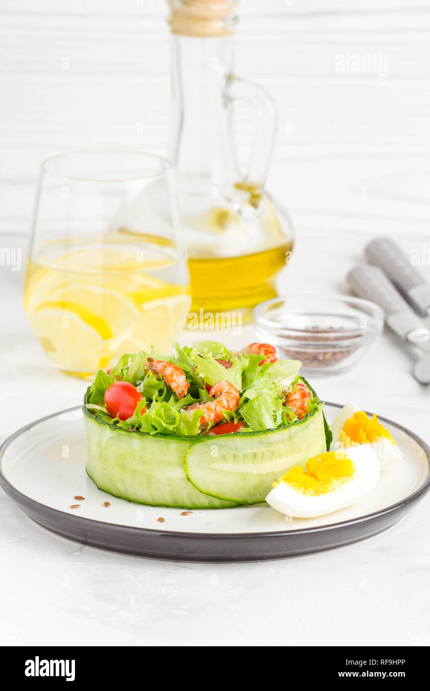 Insalata fresca con gamberi di fiume colli, lattuga, pomodori ciliegini, uovo in un anello di cetrioli Foto Stock