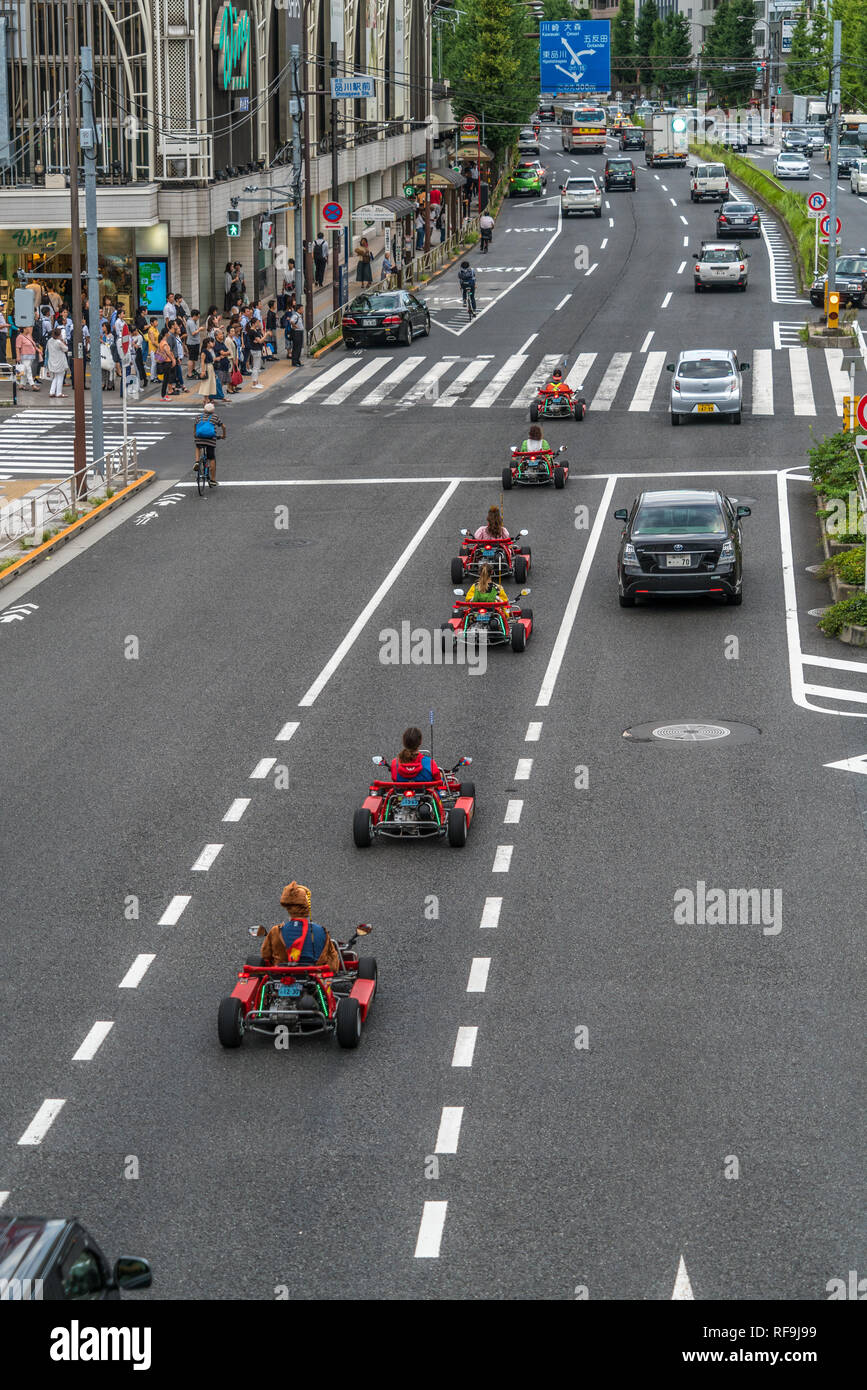 Tokyo, Shinagawa Ward - Agosto 16, 2018 - Mario Kart go-kart whizzing attraverso il traffico nel driver di Shinagawa indossando Mario costume di carattere ora banne Foto Stock