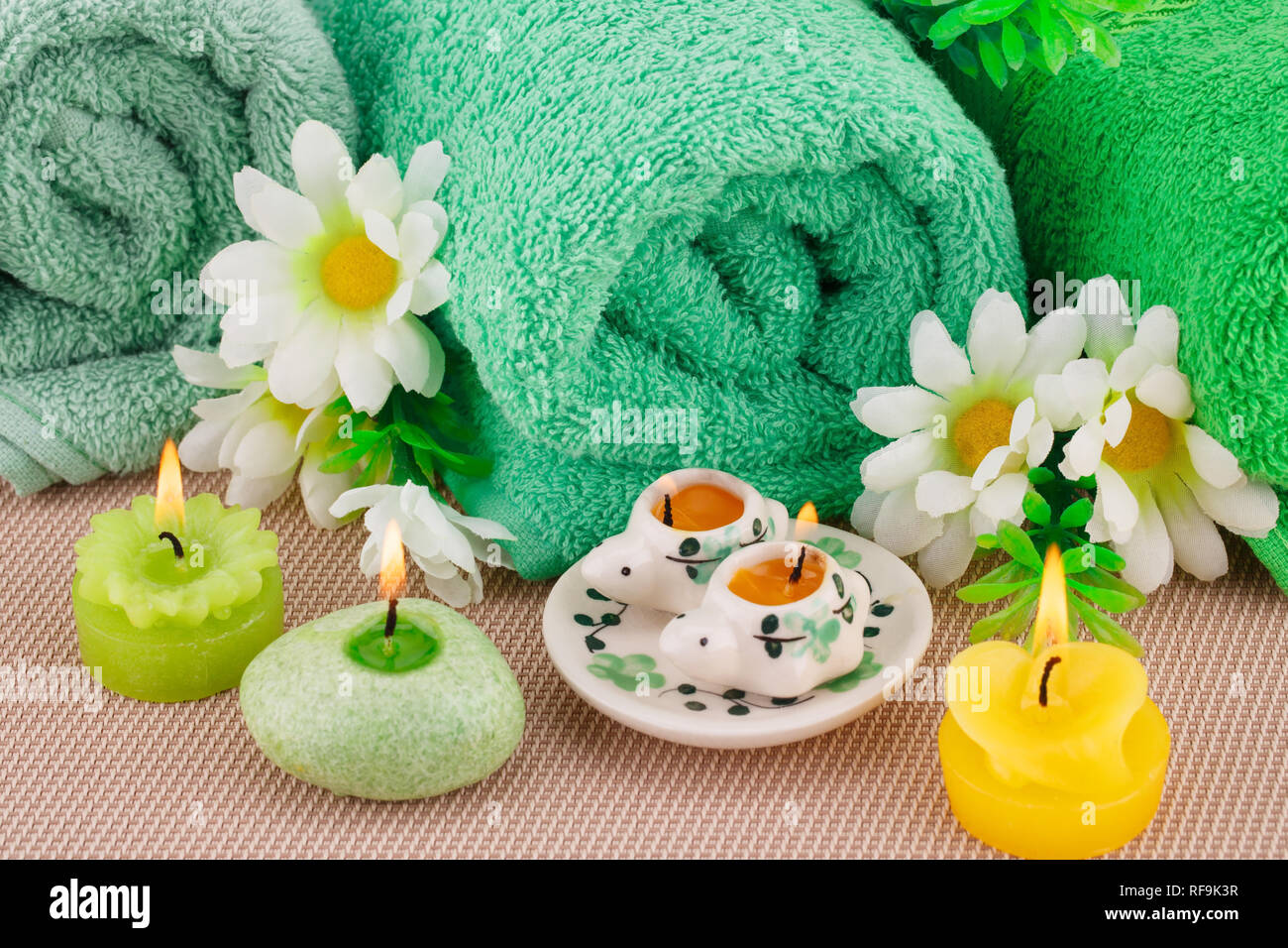 Spa con asciugamani, candele e fiori su sfondo di bambù. Foto Stock