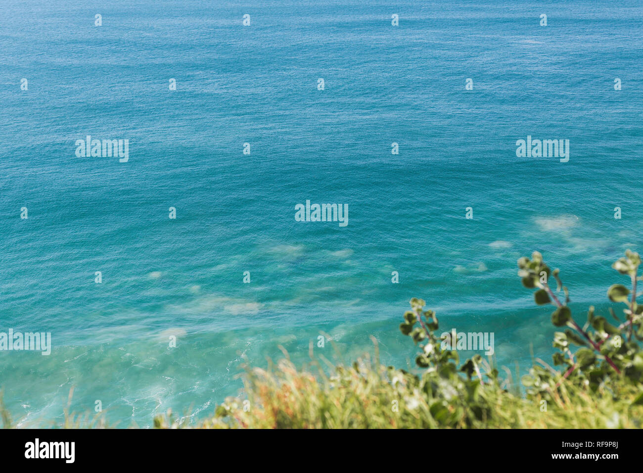 Vista di un blu brillante e oceano turchese Dalla cengia erbosa. Foto Stock