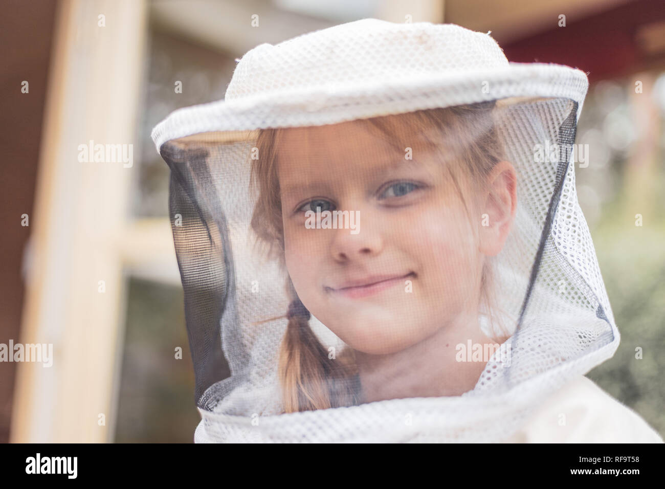 Ritratto di un 7 anno vecchia ragazza con apicoltore adatti per la protezione dalle api Foto Stock