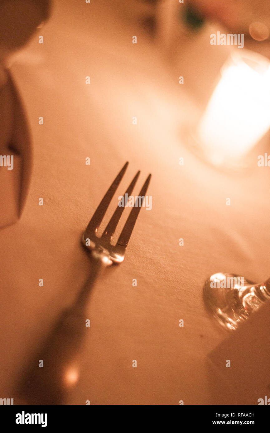 Oyster forcella recante su una impostazione tabella accanto a lume di candela a una cena di ricevimento di nozze Foto Stock