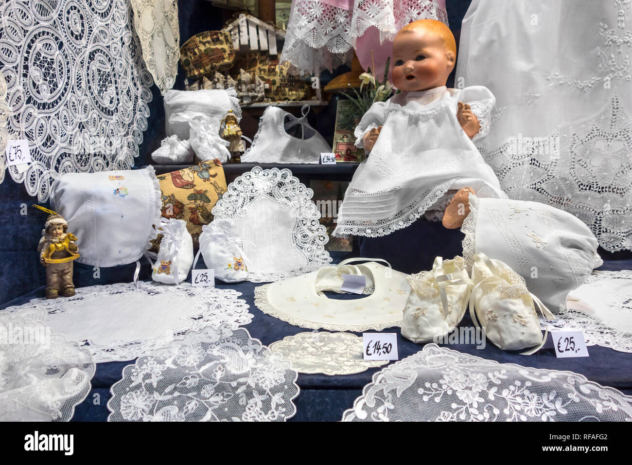Bianco belga il merletto a tombolo in vendita come souvenir turistici nella vetrina del negozio di articoli da regalo/turistica store nella città di Bruges, Fiandre Occidentali, Belgio Foto Stock