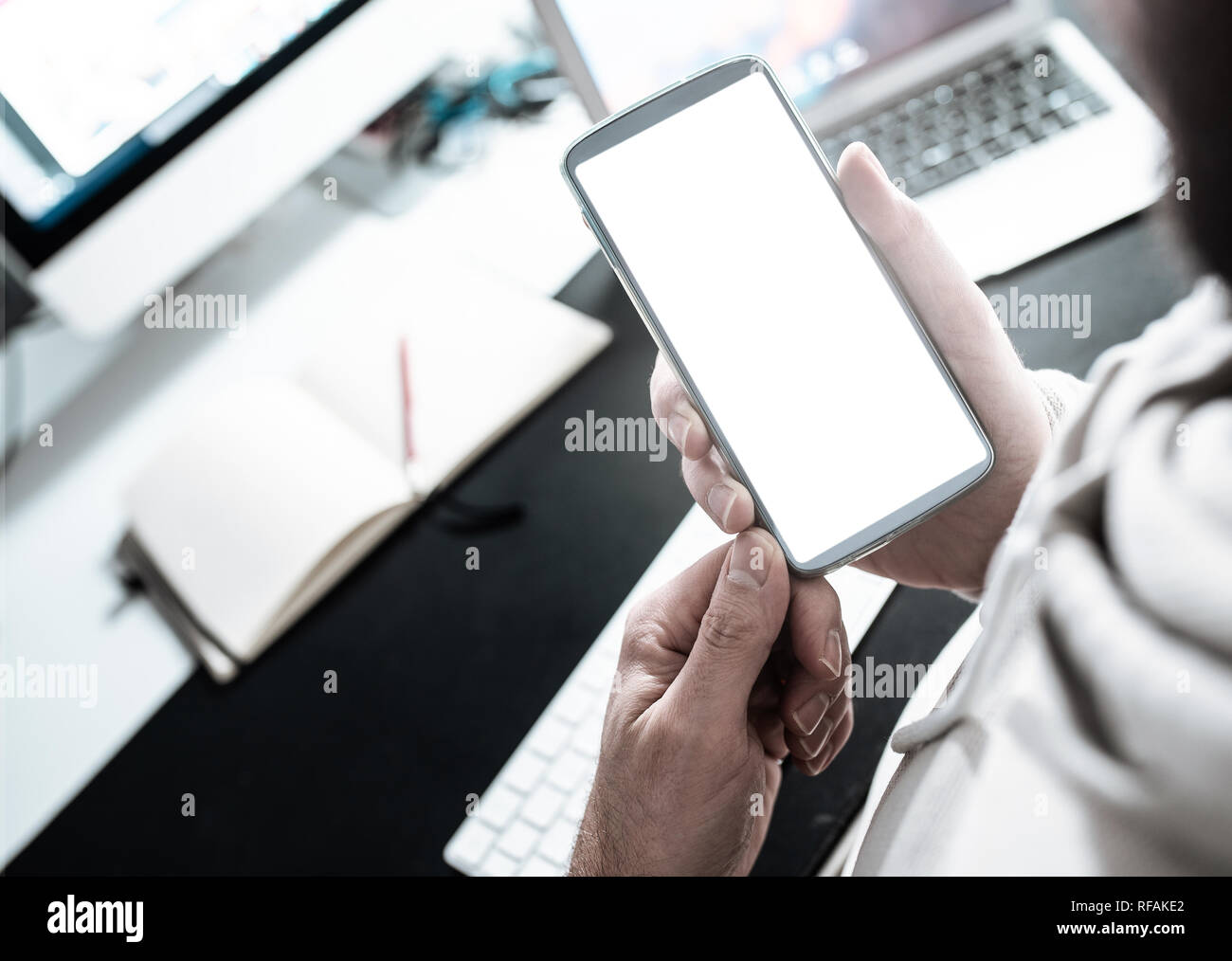 Uomo che utilizza smartphone a scrivania da ufficio Foto Stock
