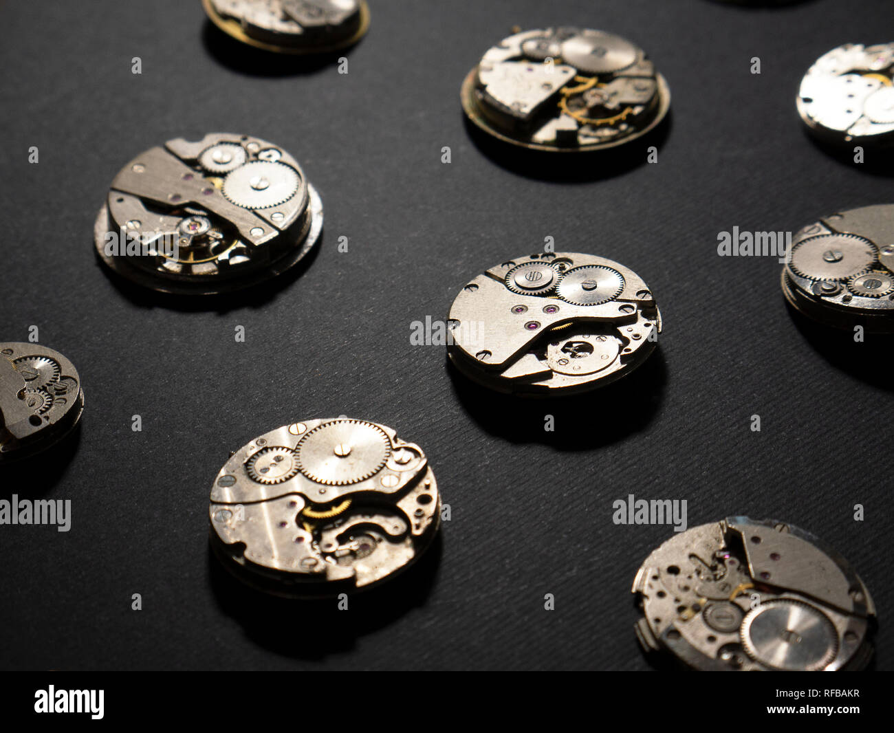 Meccanismi di orologi e loro parti su sfondo nero Foto Stock