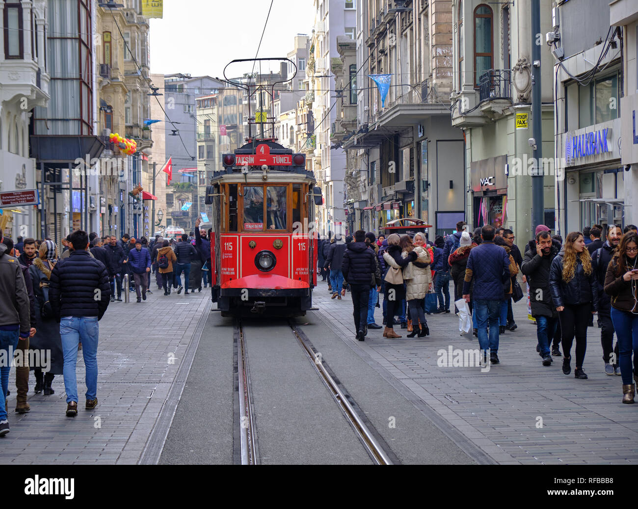 Istanbul, Turchia - Dicembre 2018 - Rosso tramvia rendendo il suo modo attraverso la folla di acquirenti su Viale Indipendenza. Foto Stock