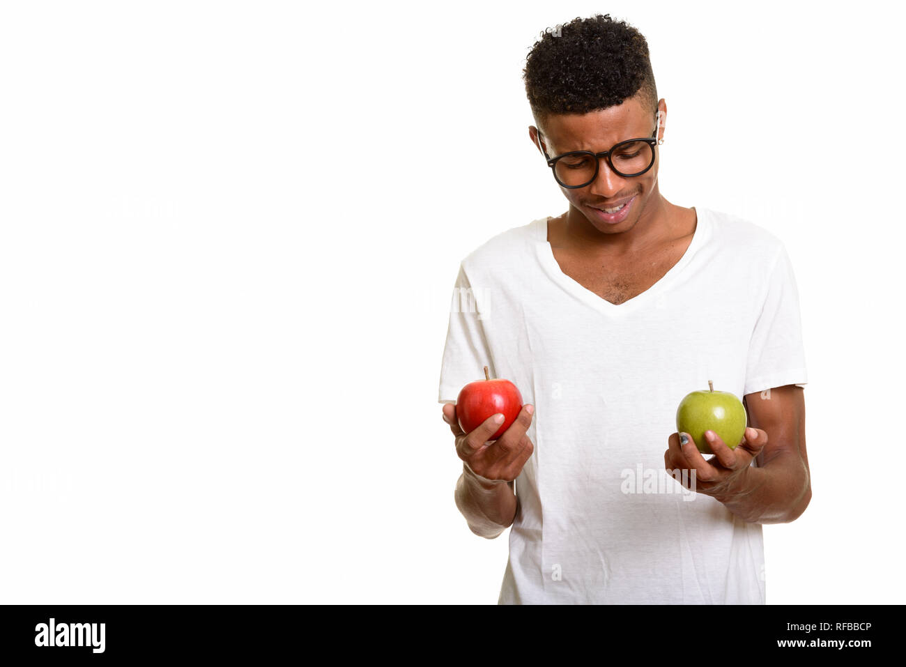 I giovani africani felice l'uomo scegliendo tra rosso e verde mela Foto Stock