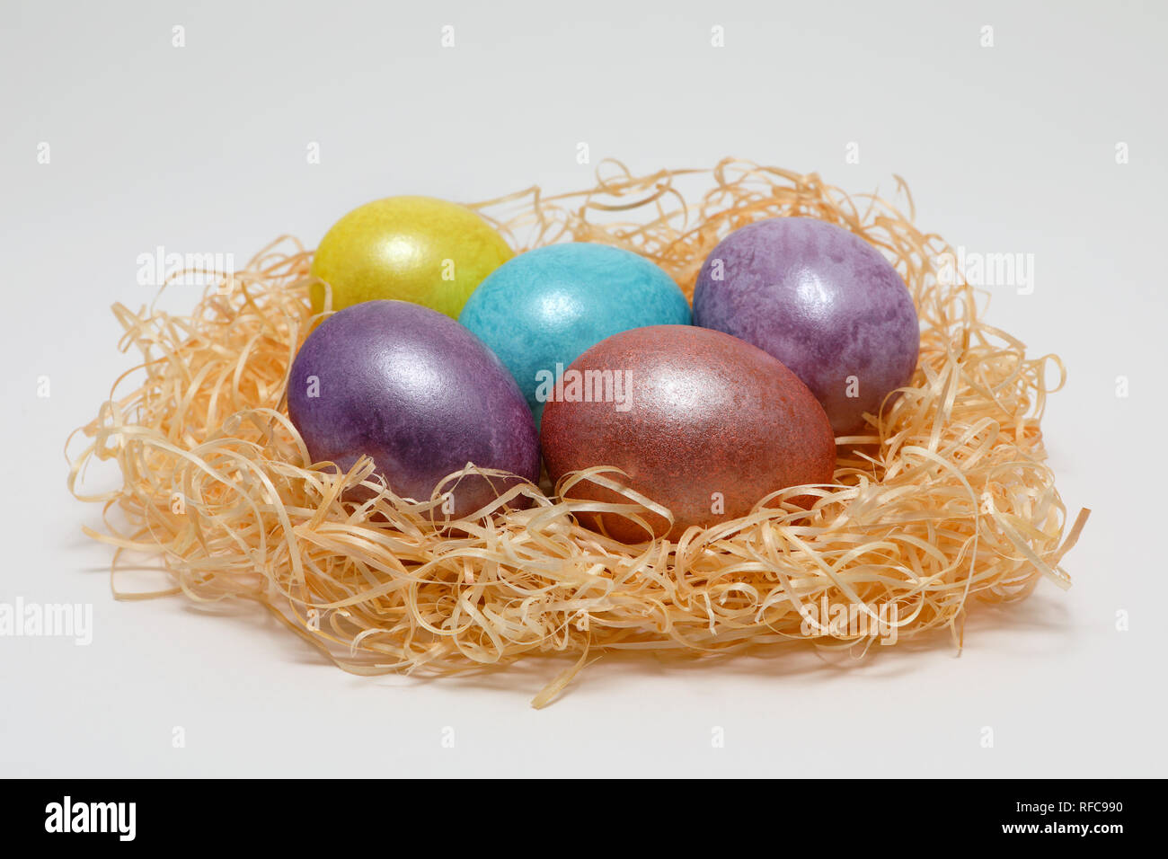 Colorate le uova di Pasqua in un nido su sfondo bianco, la molla dell'immagine. Concetto di pasqua. Foto Stock