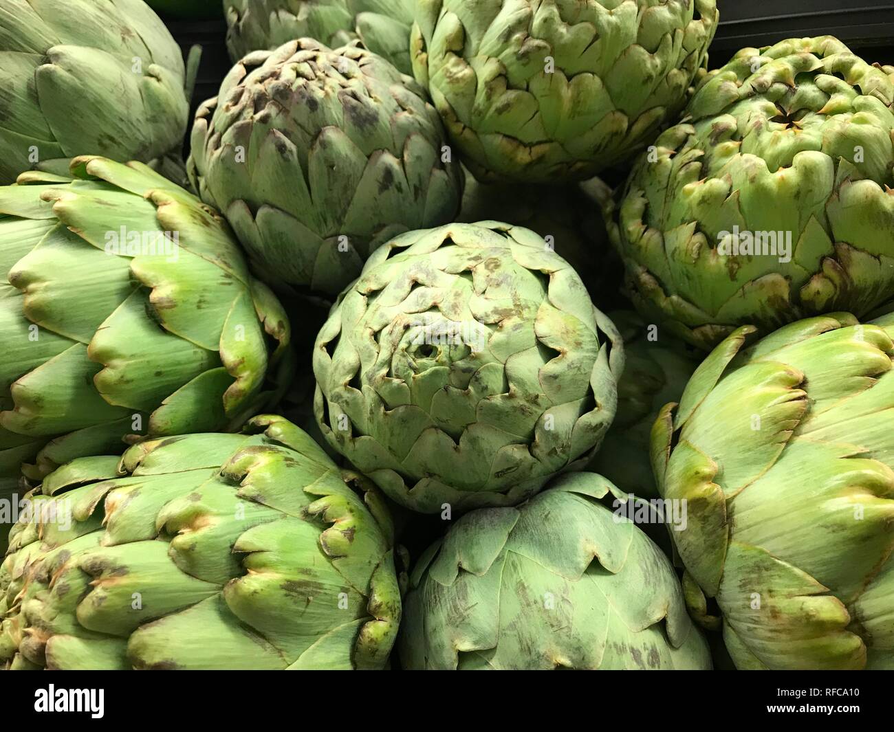 Carciofi pila ortaggi freschi di sfondo verde il mercato degli agricoltori di alimenti freschi mangiare sano Foto Stock